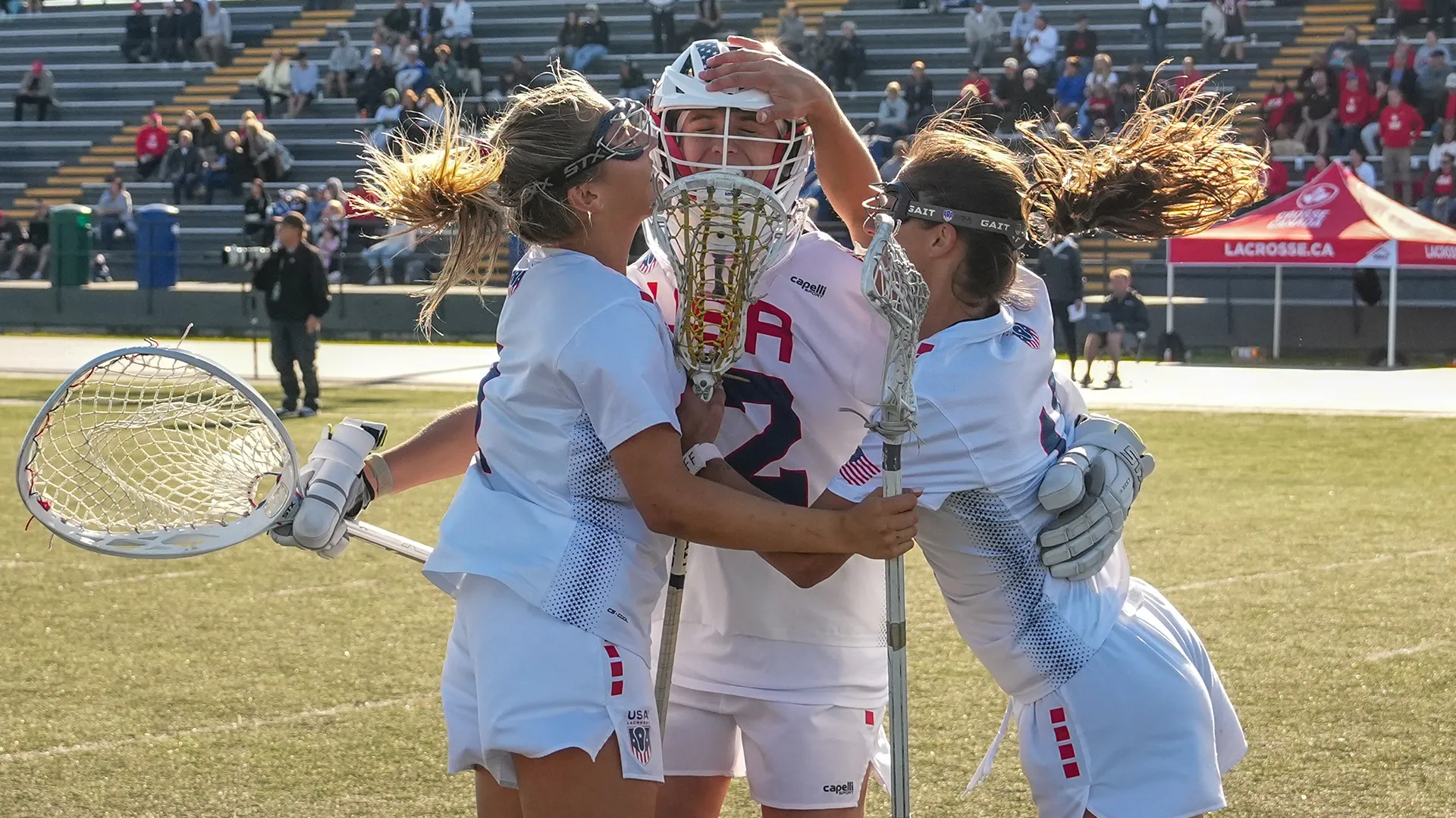 Chloe Humphrey, Taylor Moreno and Emma LoPinto celebrate after the final buzzer of a 15-14 win over Canada at the Pan-American Sixes Lacrosse Championship in Oshawa, Ontario.