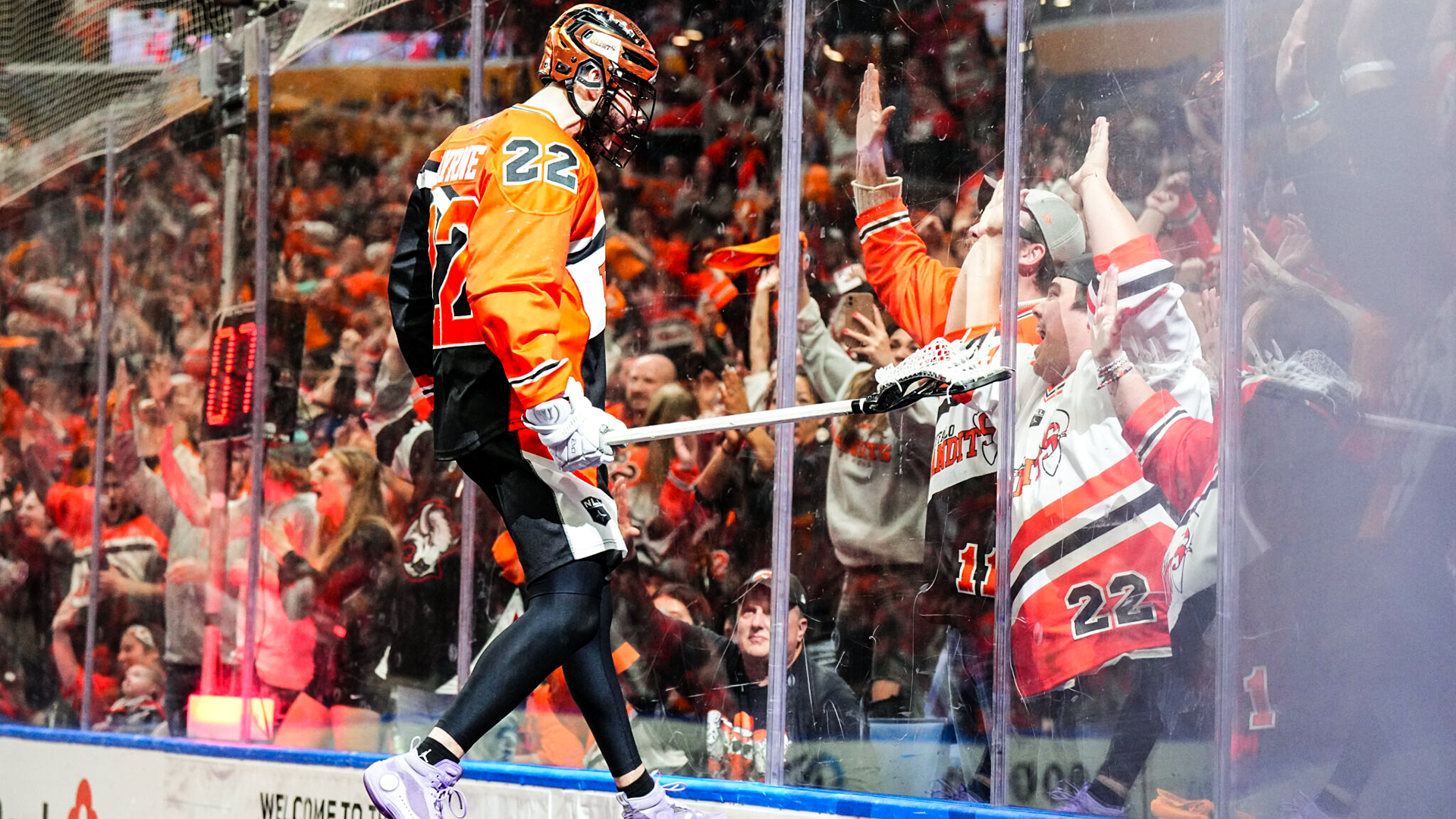Buffalo Bandits star Josh Byrne leaps into the boards toward the adulation of fans at Key Bank Center.