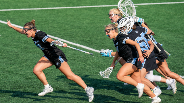 Johns Hopkins women's lacrosse players celebrate an OT victory over Michigan in Ann Arbor.