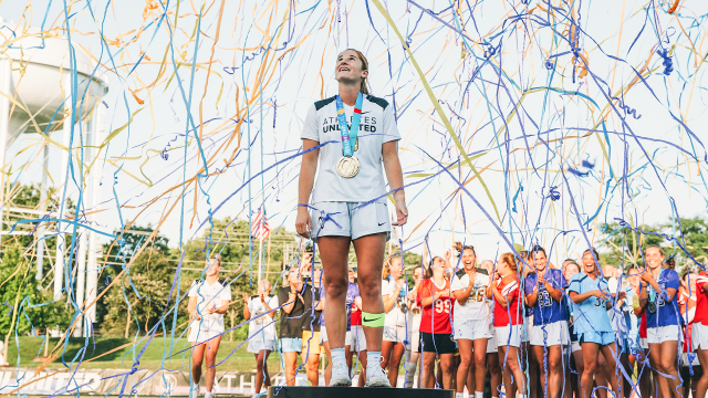 Sam Apuzzo surrounded by confetti as she stands on the champion's pedestal following the Athletes Unlimited season finale at USA Lacrosse in Sparks, Md.