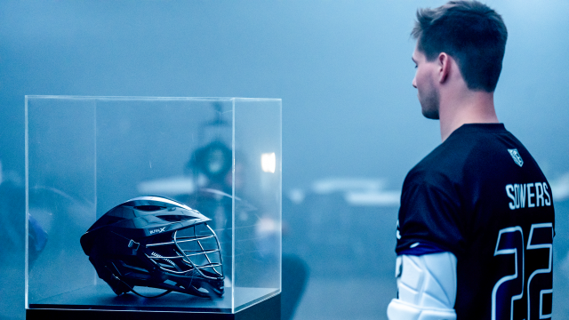 Philadelphia Waterdogs attackman eyes the new Warrior Burn X helmet inside a glass case