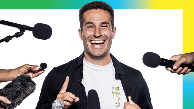 Mitchell Pehlke smiling at a podium with microphones and hands in his face during a USA Lacrosse Magazine photo shoot in Sparks, Md.