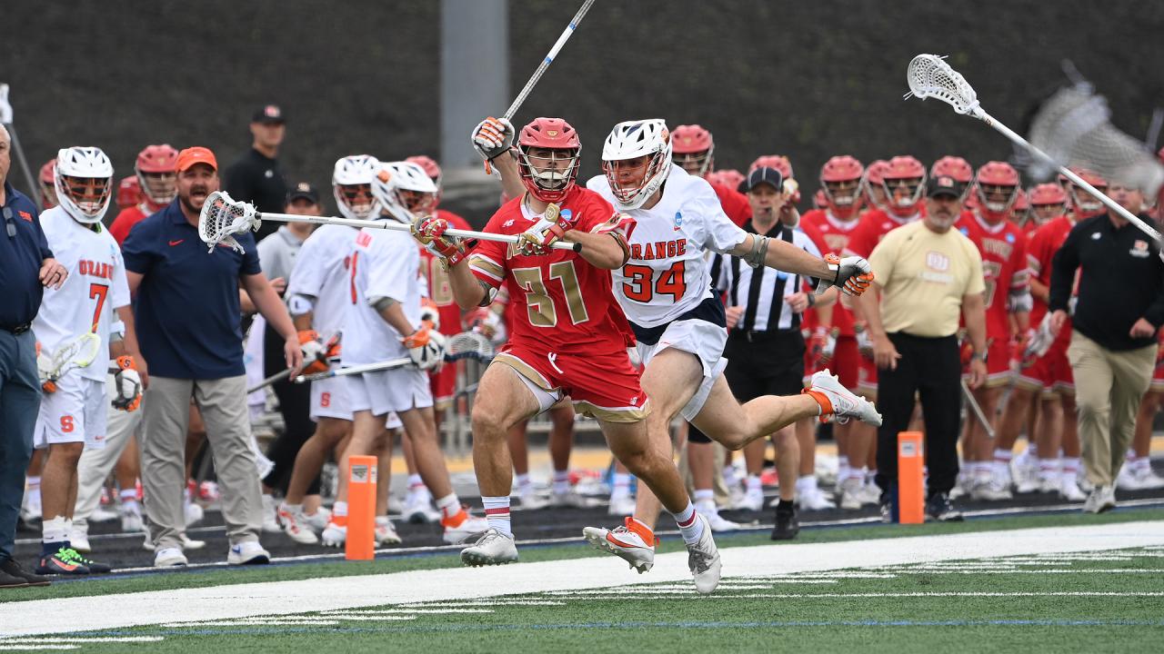 Denver defenseman Jack DiBenedetto advances the ball up the field as a Syracuse player gives chase in the NCAA quarterfinals at Towson.