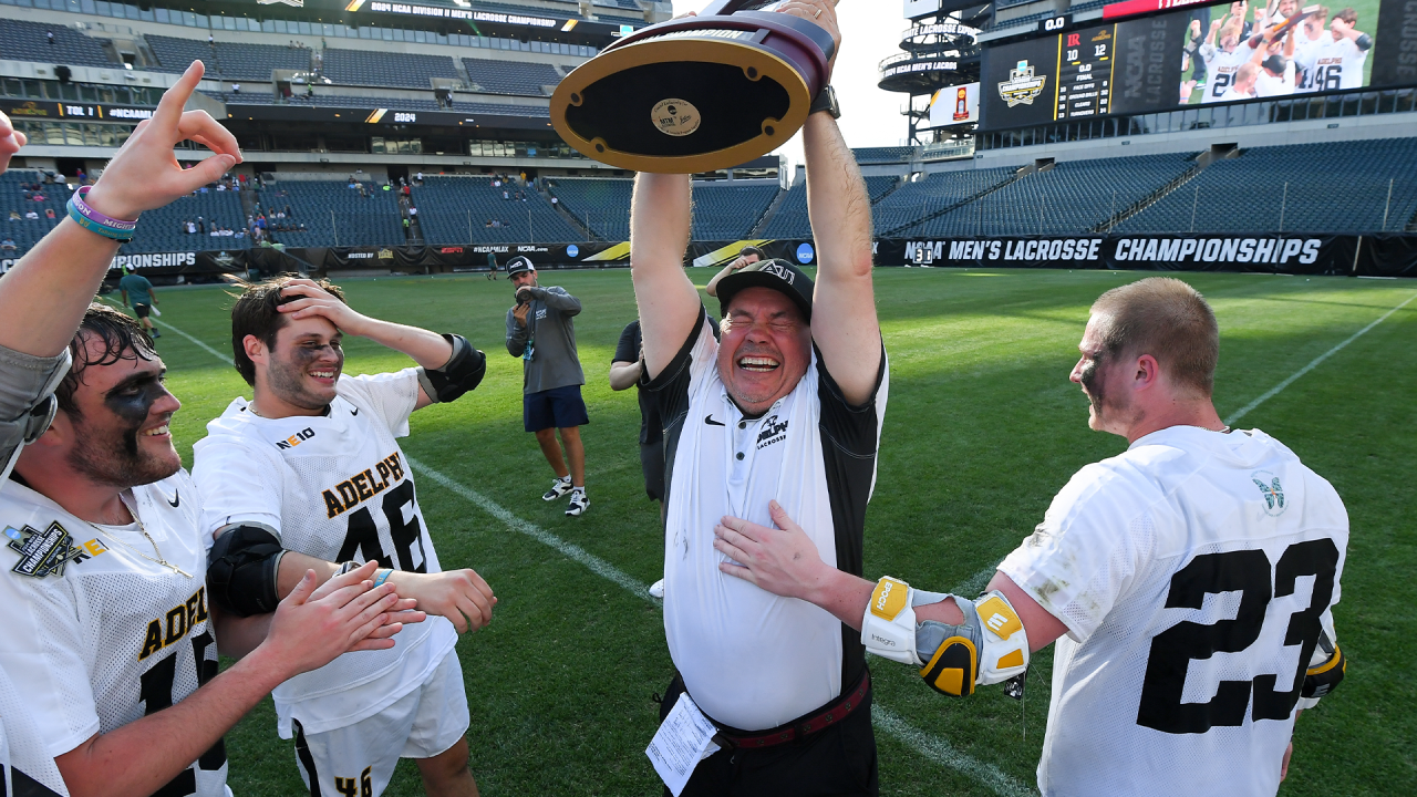 Adelphi men's lacrosse coach Gordon Purdie overjoyed as he lifts the NCAA championship trophy at Lincoln Financial Field in Philadelphia.
