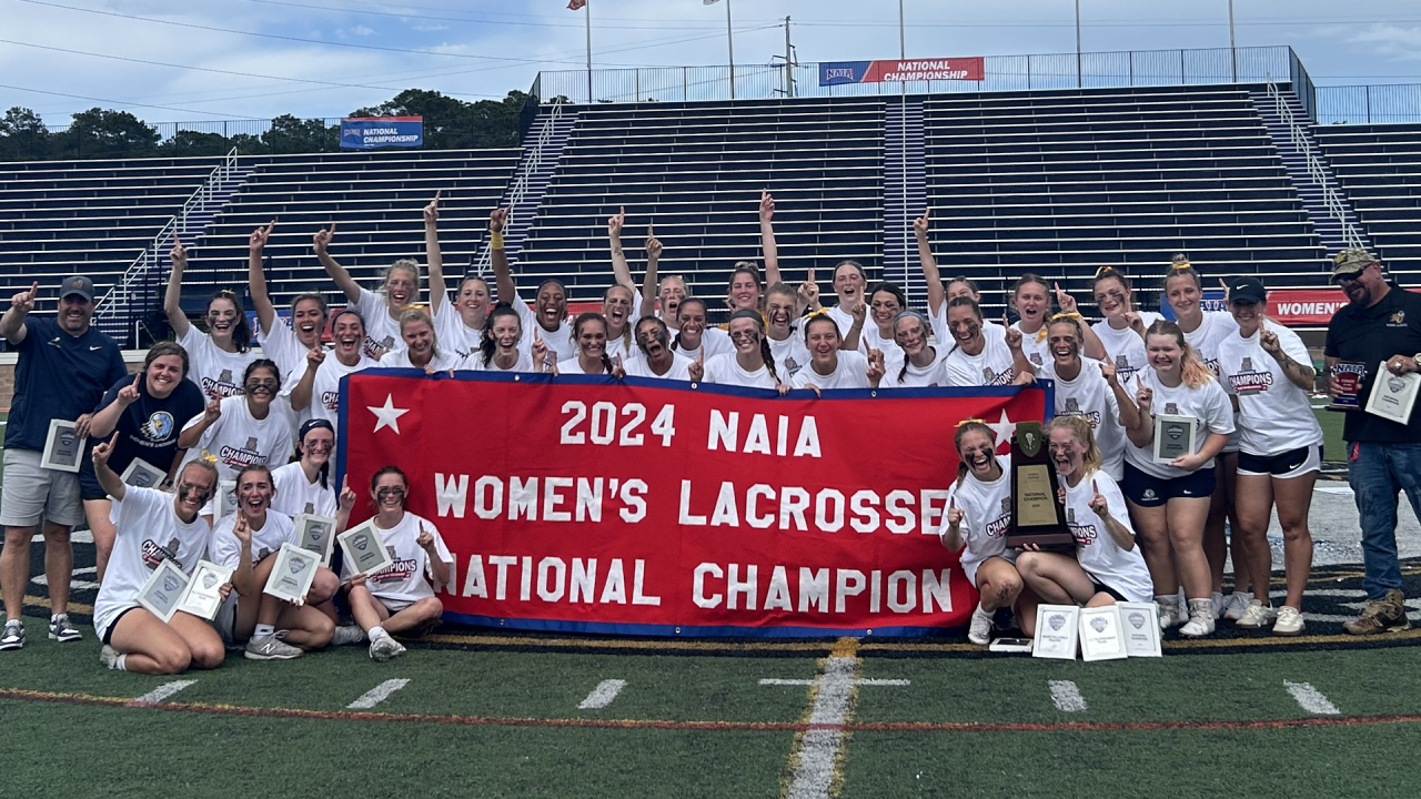 NAIA women's lacrosse champion Reinhardt (Ga.) with the championship banner